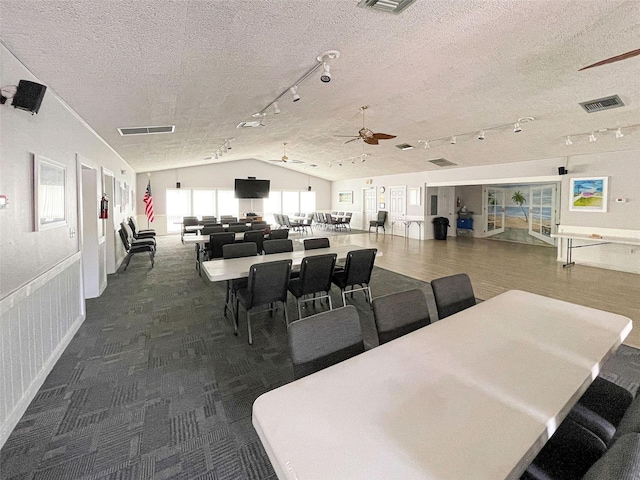 carpeted dining room featuring a textured ceiling, ceiling fan, and vaulted ceiling