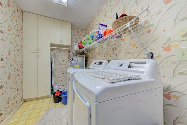 washroom with cabinets, a textured ceiling, washing machine and dryer, and water heater