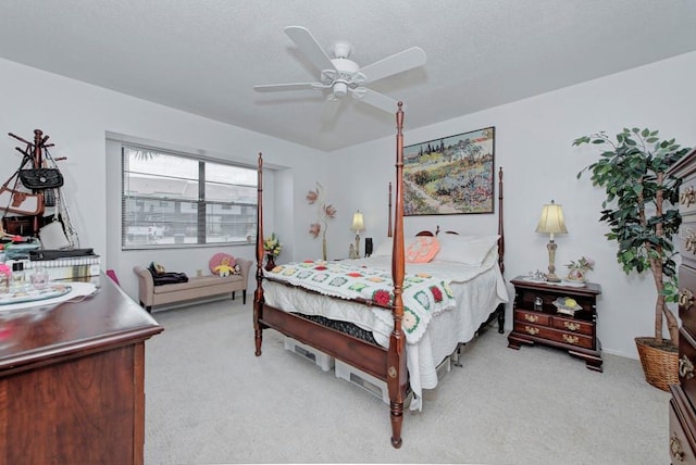 carpeted bedroom featuring ceiling fan and a textured ceiling