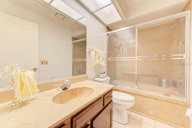 full bathroom featuring shower / bath combination with glass door, tile patterned flooring, vanity, and toilet