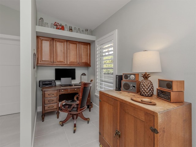 home office featuring light tile patterned flooring, lofted ceiling, and baseboards