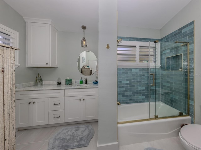 full bathroom featuring tile patterned floors, vanity, bath / shower combo with glass door, and toilet