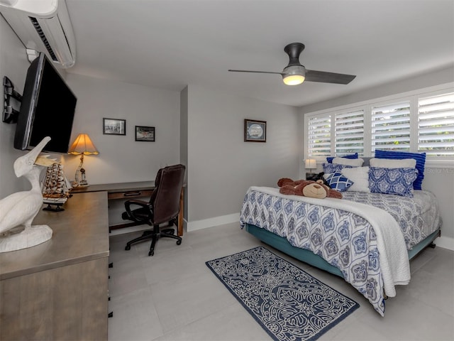 bedroom featuring an AC wall unit, a desk, ceiling fan, and baseboards