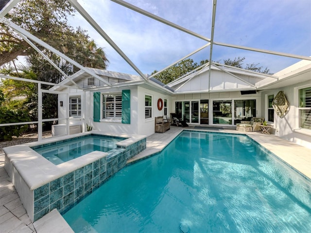 view of pool with outdoor lounge area, glass enclosure, a patio, and a pool with connected hot tub