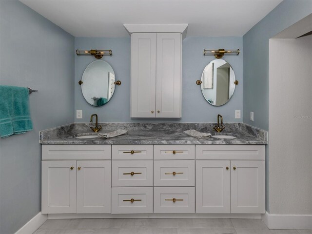 bathroom with double vanity and baseboards