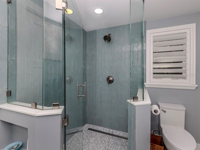 bathroom featuring tiled shower and toilet
