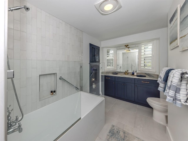 bathroom with a tile shower, vanity, tile patterned flooring, toilet, and a bath