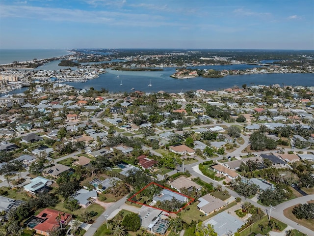 aerial view of property's location with a large body of water, property parcel outlined, and nearby suburban area