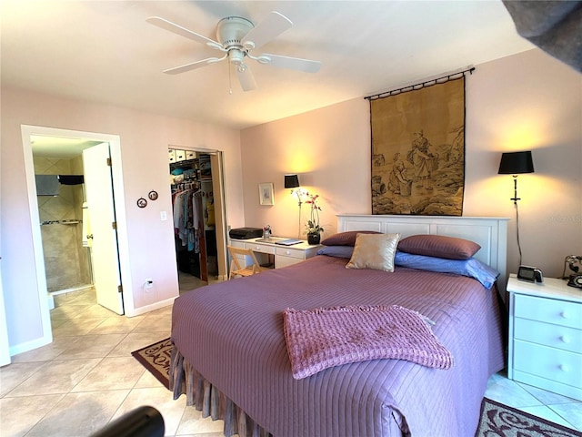 tiled bedroom featuring ceiling fan, a spacious closet, connected bathroom, and a closet