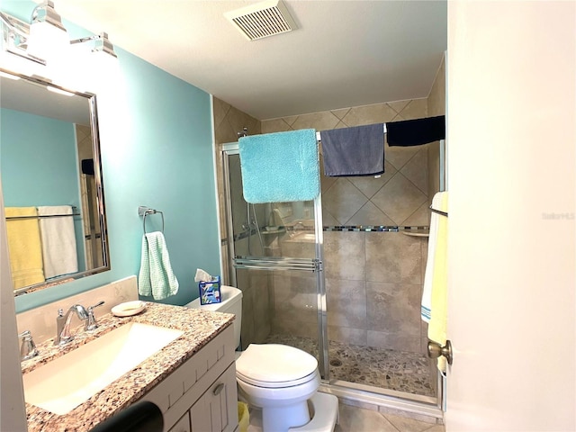 bathroom featuring tile patterned floors, vanity, toilet, and an enclosed shower