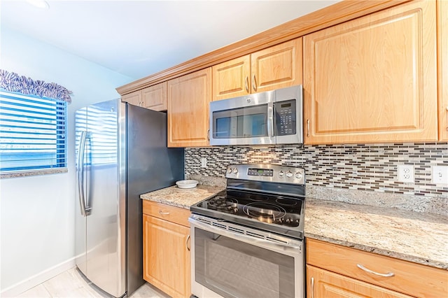 kitchen with backsplash, light stone counters, light tile patterned floors, and appliances with stainless steel finishes