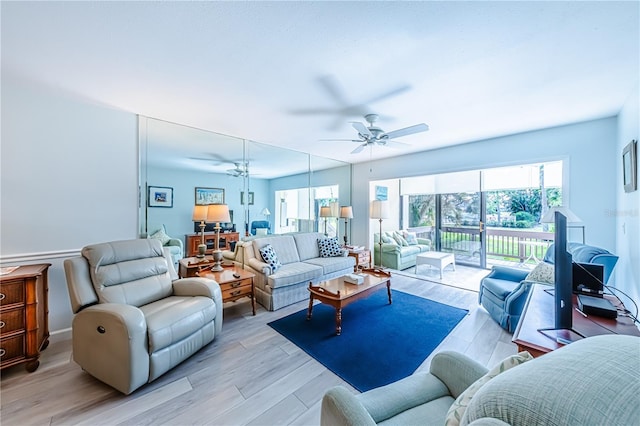 living room with light hardwood / wood-style floors, ceiling fan, and a healthy amount of sunlight