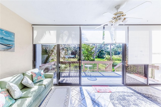 unfurnished sunroom featuring ceiling fan and a healthy amount of sunlight