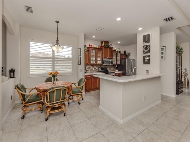 kitchen featuring light tile patterned flooring, backsplash, pendant lighting, and appliances with stainless steel finishes