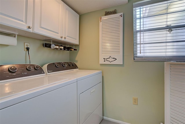 clothes washing area featuring cabinets, a healthy amount of sunlight, and independent washer and dryer