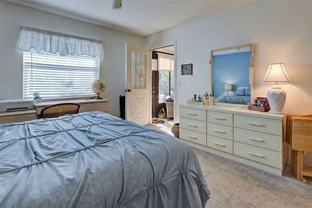 bedroom featuring light colored carpet and a textured ceiling