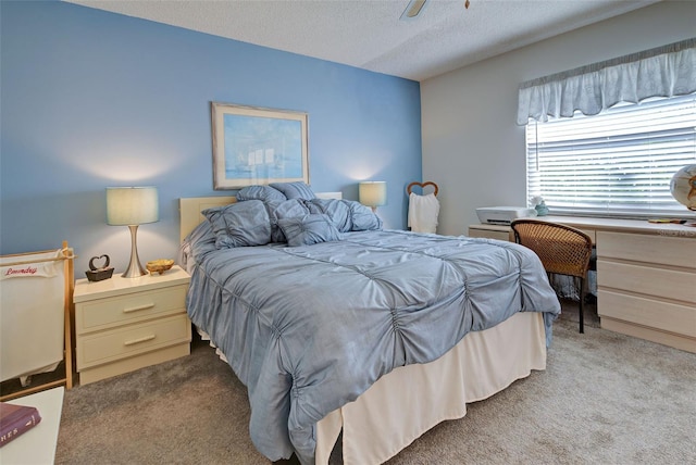 bedroom with ceiling fan, light carpet, and a textured ceiling