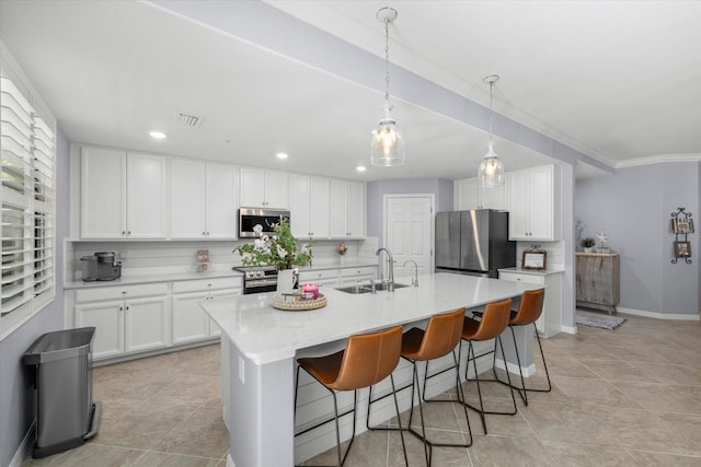 kitchen featuring white cabinetry, sink, appliances with stainless steel finishes, and an island with sink