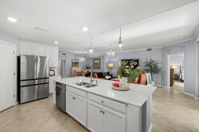 kitchen with white cabinets, appliances with stainless steel finishes, an island with sink, and sink