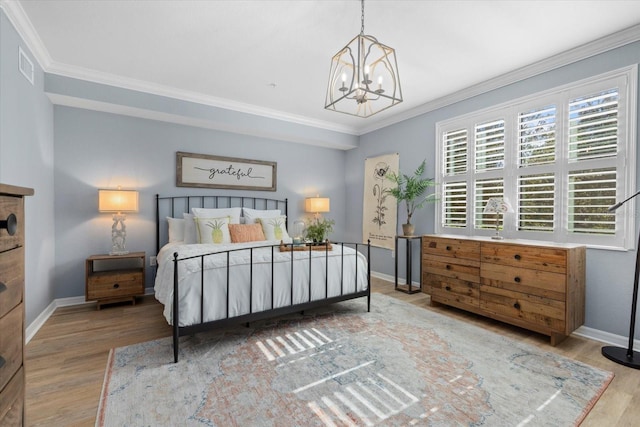 bedroom with hardwood / wood-style floors, an inviting chandelier, and crown molding