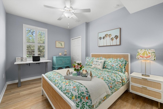 bedroom with a closet, light hardwood / wood-style flooring, and ceiling fan