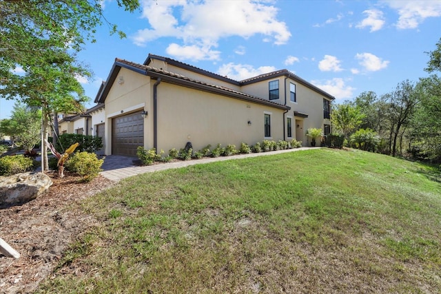 view of side of property with a lawn and a garage