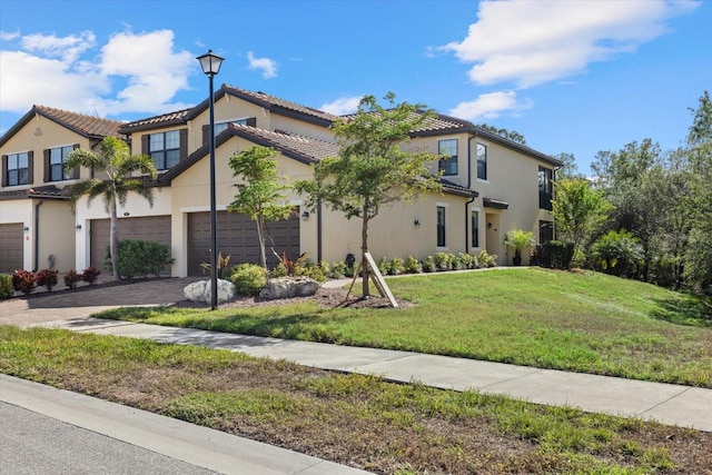 mediterranean / spanish home with a front yard and a garage