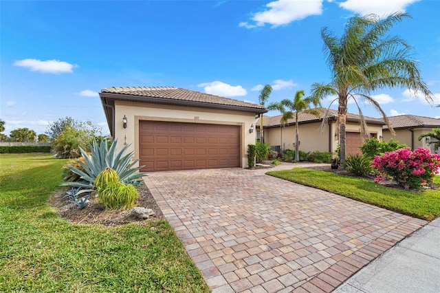 mediterranean / spanish house featuring a garage and a front yard