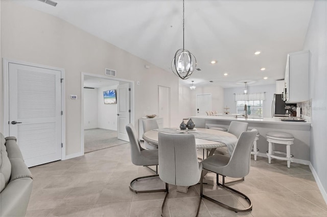 tiled dining area with a chandelier and lofted ceiling