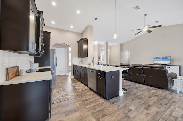 kitchen featuring appliances with stainless steel finishes, a breakfast bar, sink, hardwood / wood-style floors, and hanging light fixtures