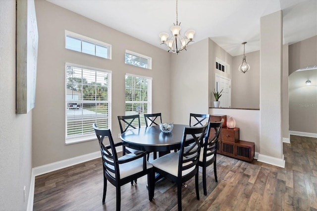 dining space featuring dark wood-type flooring and a notable chandelier