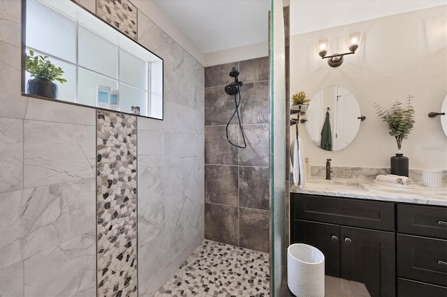 bathroom with vanity and a tile shower