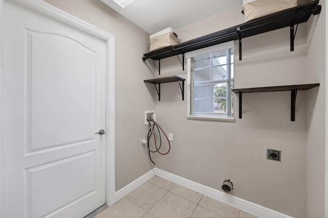 laundry area featuring washer hookup, electric dryer hookup, and light tile patterned flooring