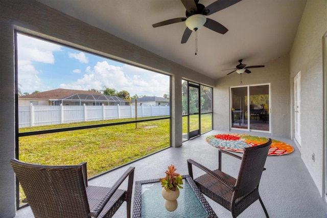 sunroom / solarium featuring a water view and ceiling fan