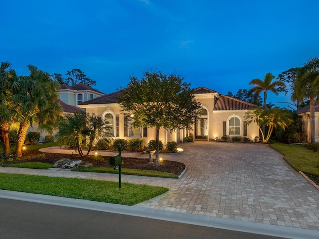 mediterranean / spanish house featuring a lawn