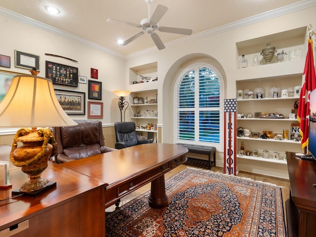 office area with built in shelves, ceiling fan, and ornamental molding