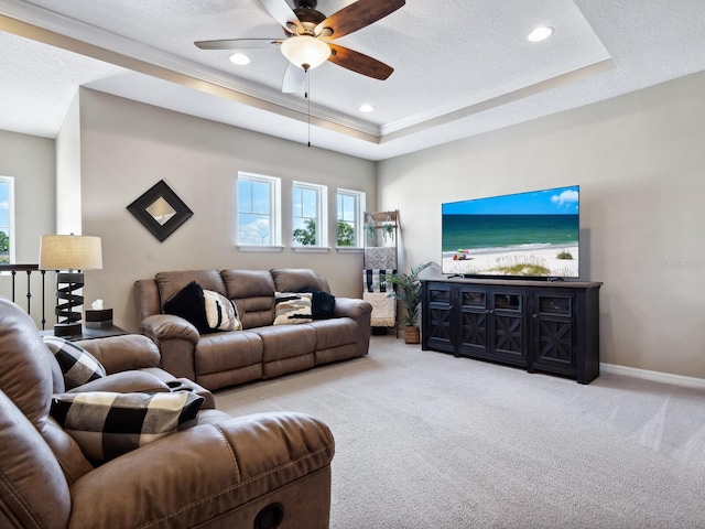 carpeted living room with a tray ceiling, ceiling fan, and a textured ceiling