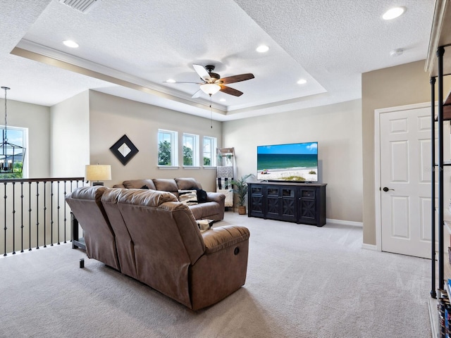 carpeted living room with ceiling fan, a textured ceiling, and a tray ceiling