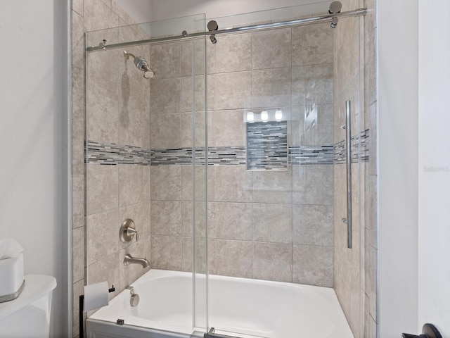 bathroom with bath / shower combo with glass door and toilet