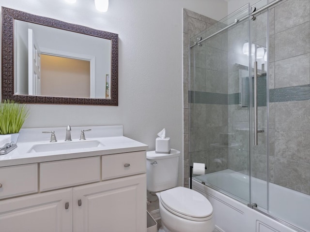 full bathroom with combined bath / shower with glass door, vanity, and toilet