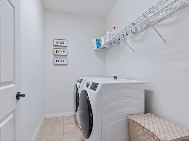 laundry room featuring light tile patterned floors and separate washer and dryer