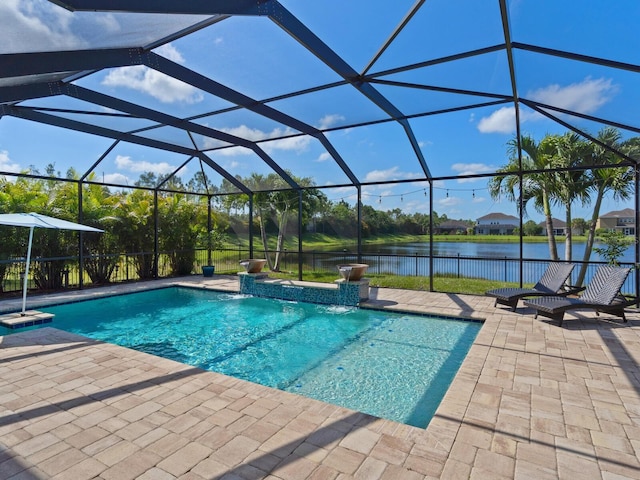 view of pool with pool water feature, a water view, glass enclosure, and a patio area