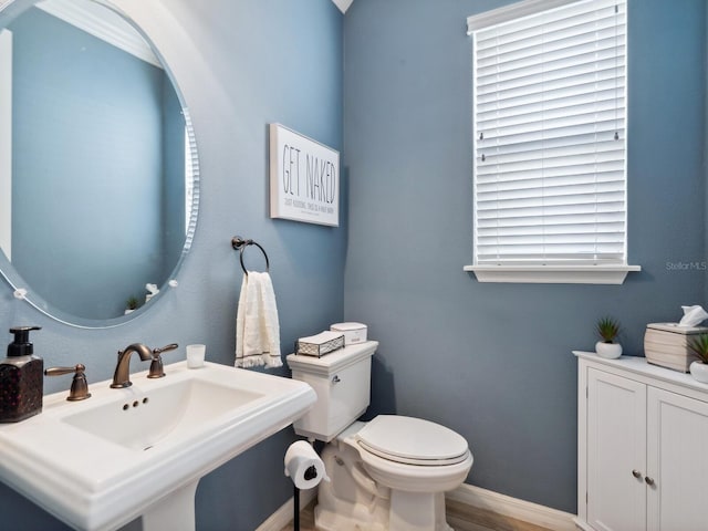 5930 Anise Dr, Sarasota, FL 34238 - half bath with wood finished floors, toilet, baseboards, and a sink