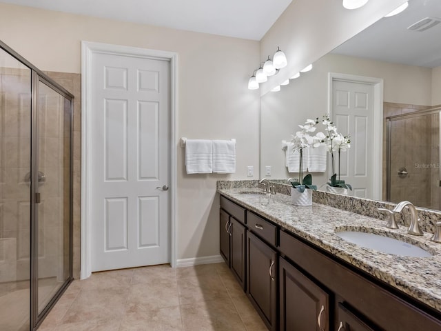 bathroom featuring a shower with shower door, tile patterned floors, and vanity