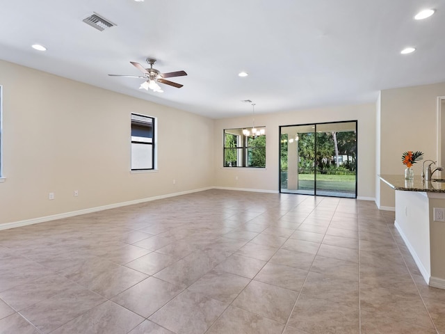 spare room with sink, ceiling fan with notable chandelier, and light tile patterned floors