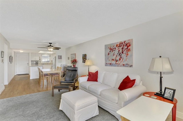 living room with ceiling fan and light hardwood / wood-style flooring