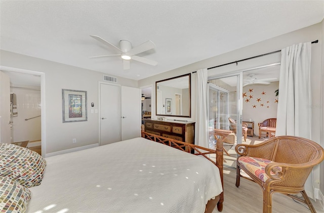 bedroom featuring access to outside, ceiling fan, light hardwood / wood-style floors, and a textured ceiling