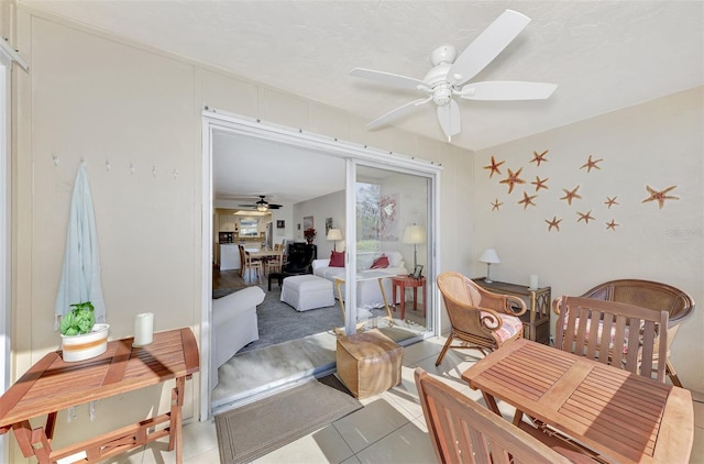 living area featuring ceiling fan and light tile patterned flooring