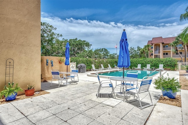 view of patio featuring area for grilling and a community pool