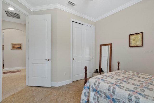 bedroom with light tile patterned floors, a closet, and crown molding